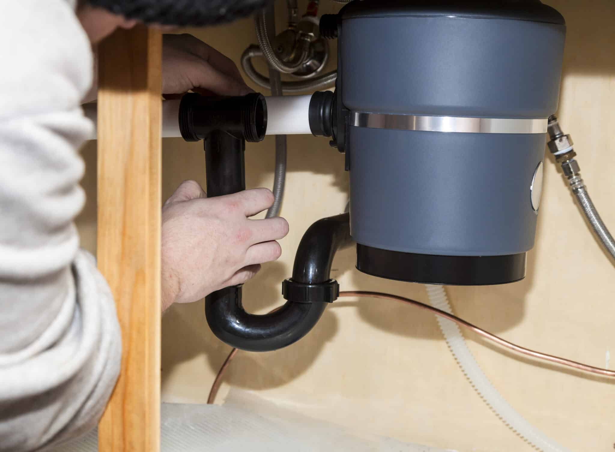 Man installing garbage disposal in home, Garbage Disposal Repair.